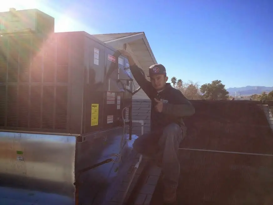 HVAC technician performing Boiler Repair on a rooftop unit in Patterson
